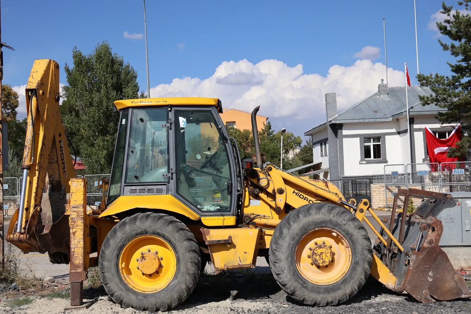 Yusuf Dumlu'nun kazıcı-yükleyicisi yandan, arka kazıcı kolu ve ön kovasıyla