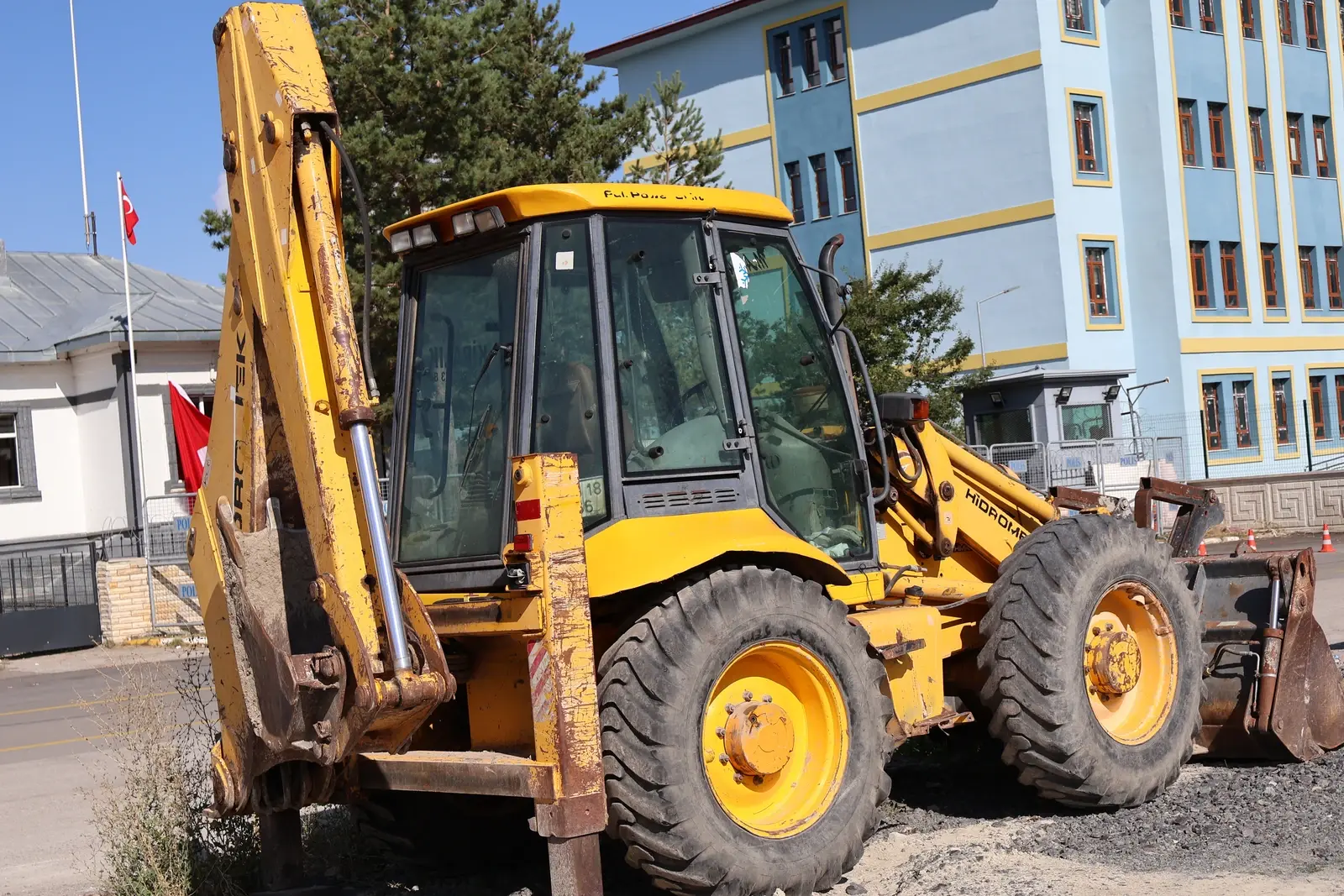 Backhoe loader with its rear digging arm and cab, ready to head to the site